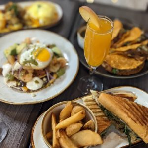 brunch spread with mimosa eggs and sandwich
